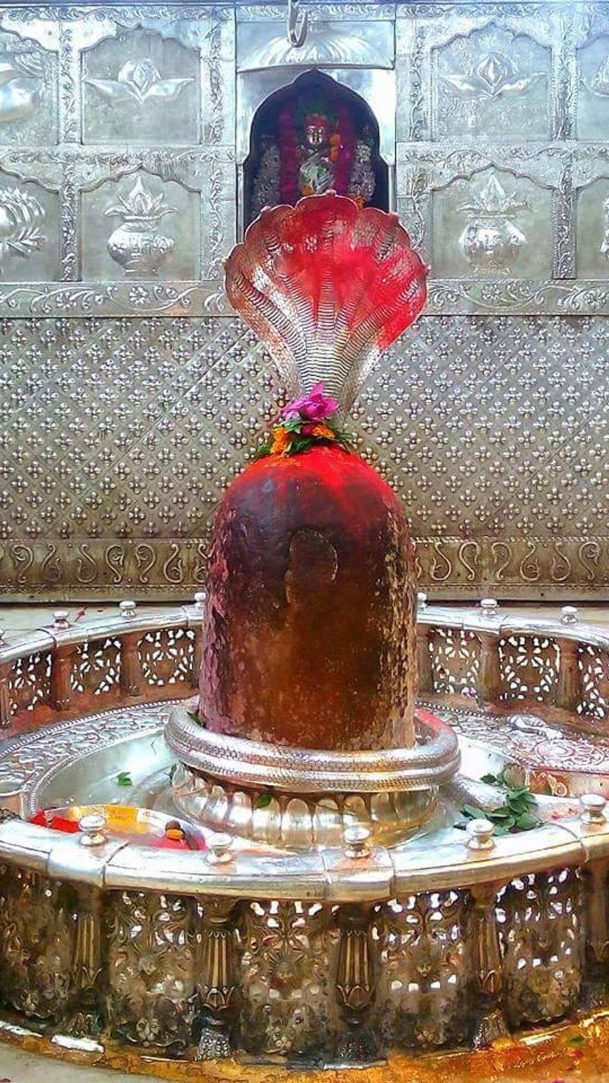 Sacred Shiva Lingam Adorned with Red Kumkum and Silver Peacock Feather in Temple HD phone wallpaper
