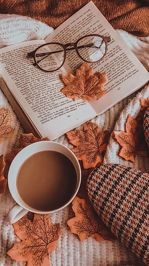 Cozy Autumn Reading Scene with Coffee, Glasses, and Maple Leaves on Knit Blanket HD phone wallpaper