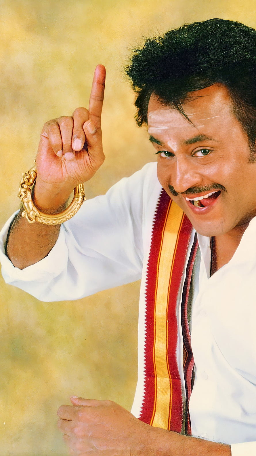 Rajinikanth in traditional white attire with gold bangles and a red and yellow sash HD phone wallpaper