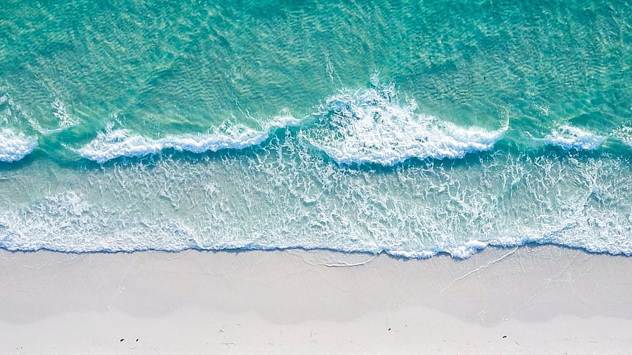Aerial View of Turquoise Ocean Waves Rolling onto White Sandy Beach HD wallpaper