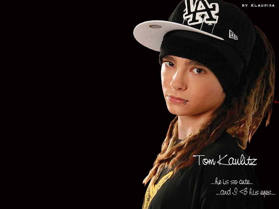 Tom Kaulitz of Tokio Hotel in a black cap and beanie with dreadlocks against a dark background HD wallpaper