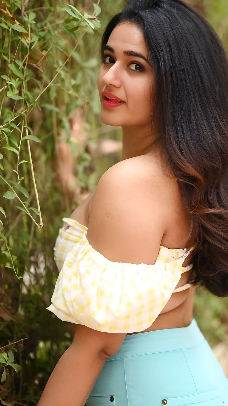 Poonam Bajwa in a yellow gingham off-shoulder top and mint skirt against a leafy garden backdrop HD phone wallpaper