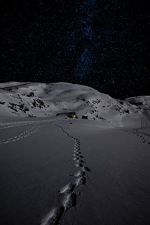 Snowy Mountain Trail Under the Milky Way with Footprints Leading to a Glowing Tent HD phone wallpaper