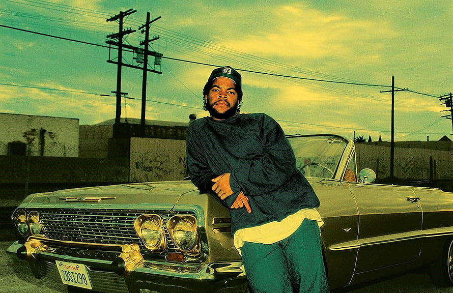 Ice Cube Leaning Against a Classic Car in a Vintage Street Scene HD wallpaper
