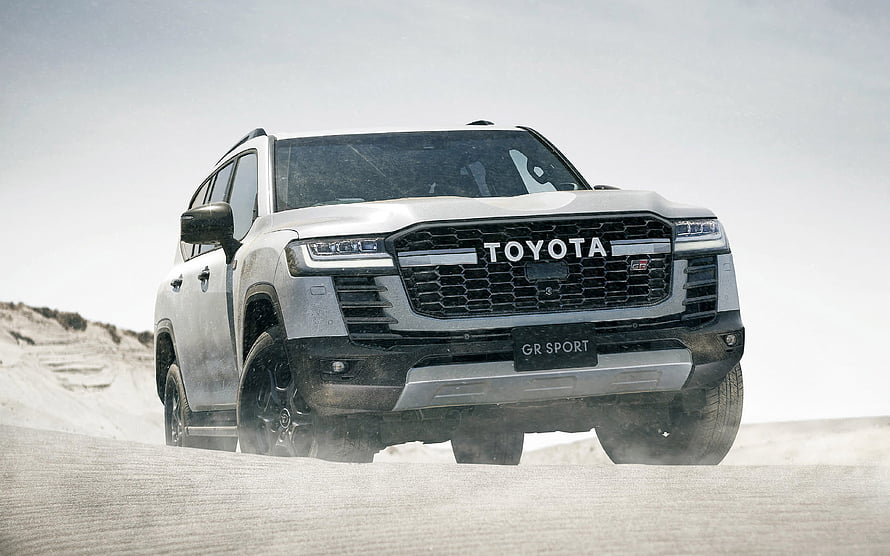 White Toyota Land Cruiser GR Sport SUV Driving on Sandy Terrain HD wallpaper
