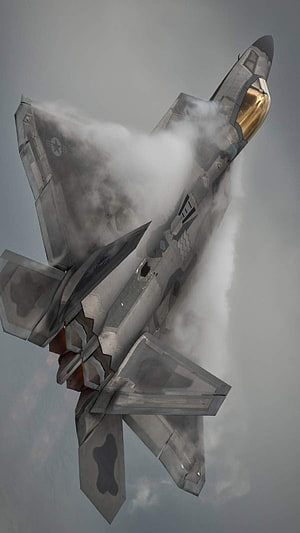 F-22 Raptor Stealth Fighter Jet Breaking Through Clouds in Dramatic Aerial Maneuver HD phone wallpaper