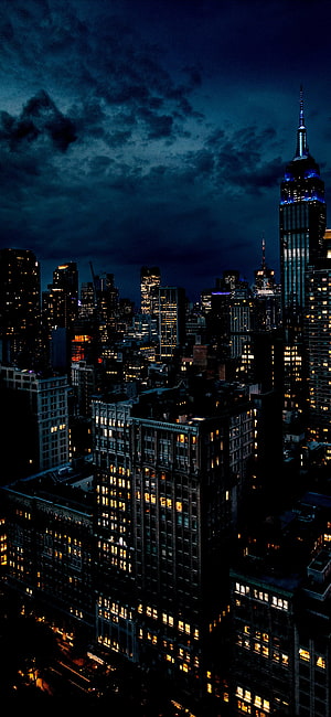 New York City Skyline at Night with Empire State Building and Dramatic Clouds HD phone wallpaper