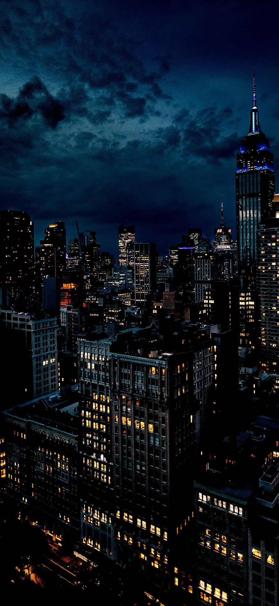 New York City Skyline at Night with Empire State Building and Dramatic Clouds HD phone wallpaper