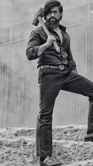 Yash in KGF Character Pose with Sledgehammer in Black and White HD phone wallpaper