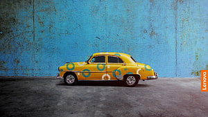 Vintage Yellow Car With Blue Circles Parked Against A Textured Blue Wall HD wallpaper