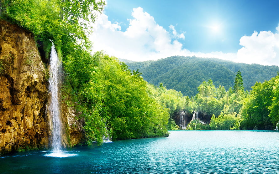 Serene Waterfall Cascading Into Turquoise Lake Surrounded By Lush Green Forest HD wallpaper