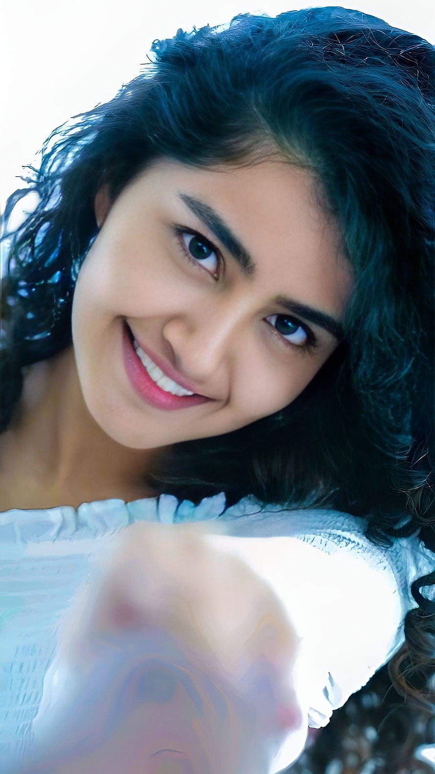 Portrait of a smiling woman with dark curly hair and blue eyes wearing a white top, Anupama parmeshwaran, anupama, multilingual actress HD phone wallpaper