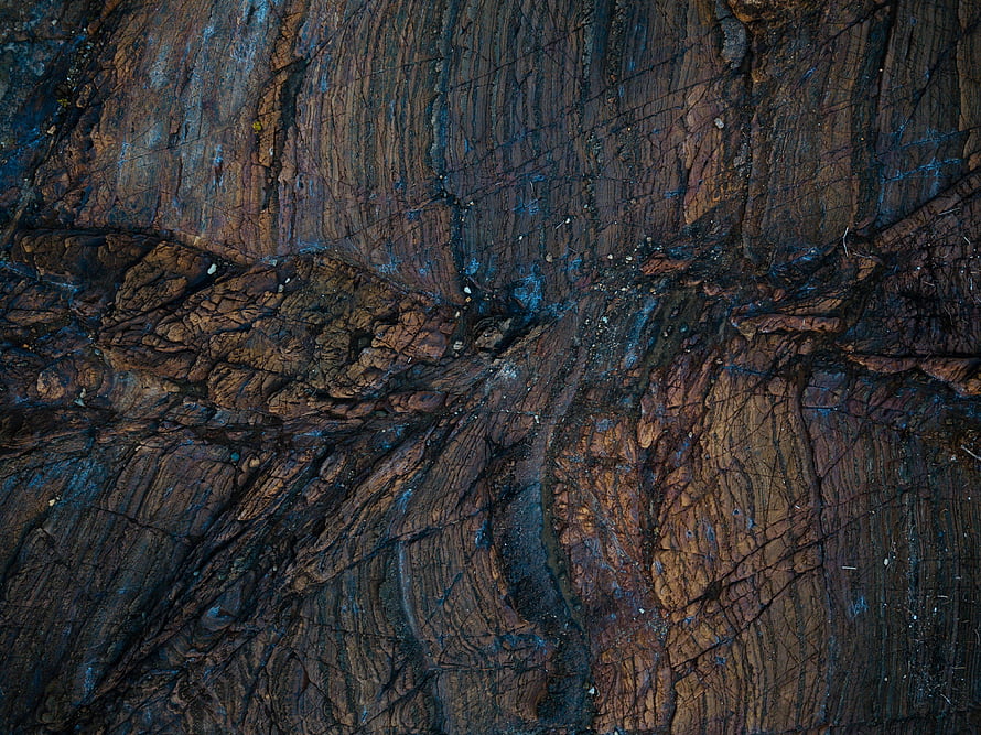 Dark Textured Rock Surface With Blue And Brown Mineral Veins HD wallpaper