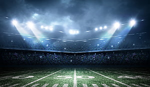 Dramatic Nighttime American Football Stadium With Bright Floodlights And Packed Crowd HD wallpaper