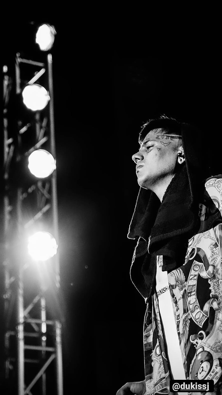 Duki performing on stage in black and white with dramatic lighting and face tattoos HD phone wallpaper