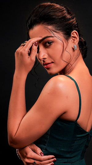 Rashmika Mandanna in an elegant dark green dress with a poised studio portrait HD phone wallpaper