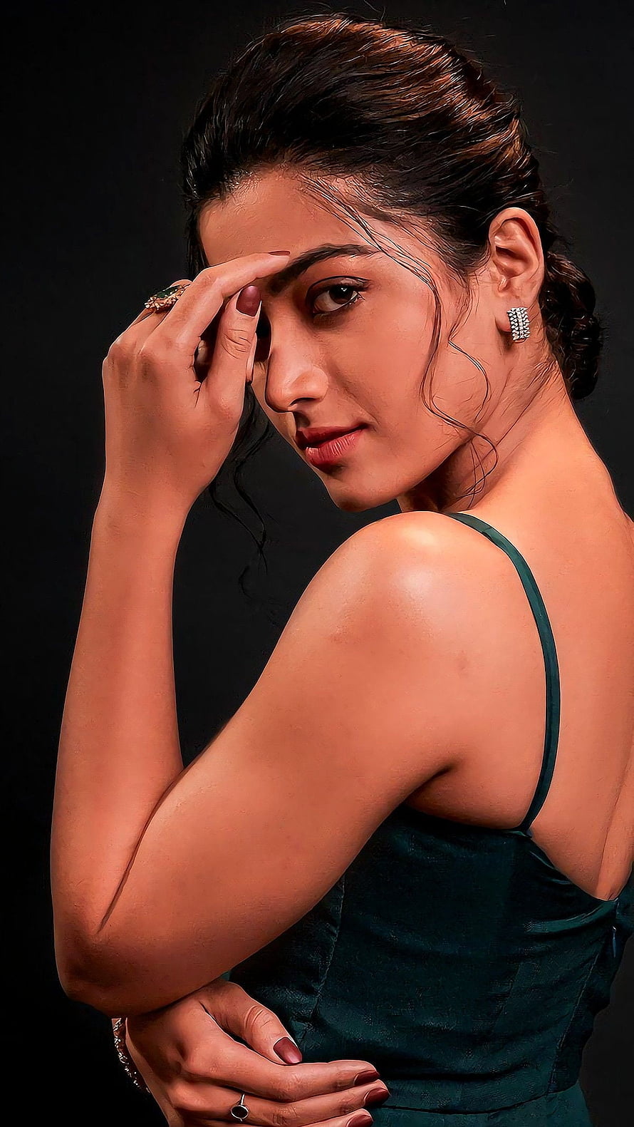 Rashmika Mandanna in an elegant dark green dress with a poised studio portrait HD phone wallpaper