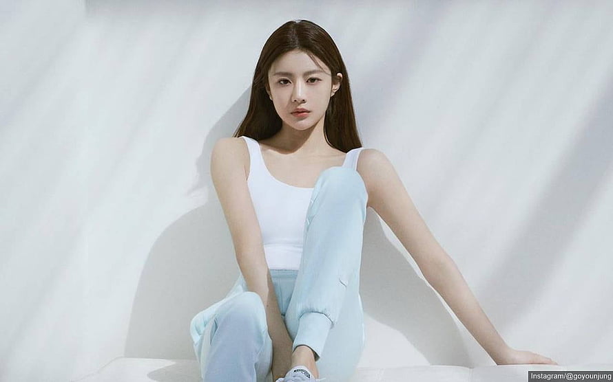 Go Yoon Jung in White Tank Top and Light Blue Pants Sitting Against White Backdrop HD wallpaper