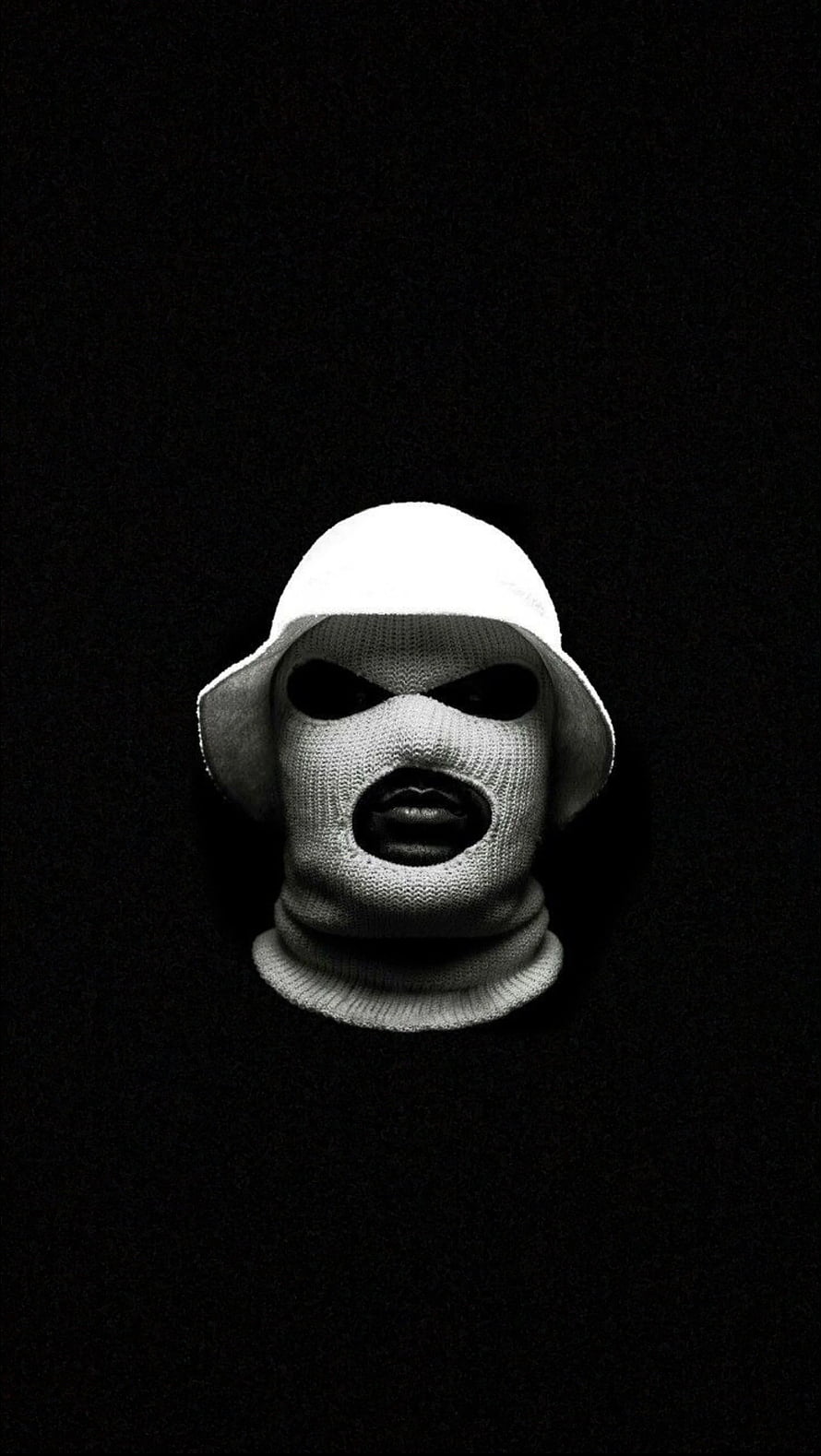 A striking black and white portrait of a person wearing a white knit balaclava and bucket hat against a dark background HD phone wallpaper
