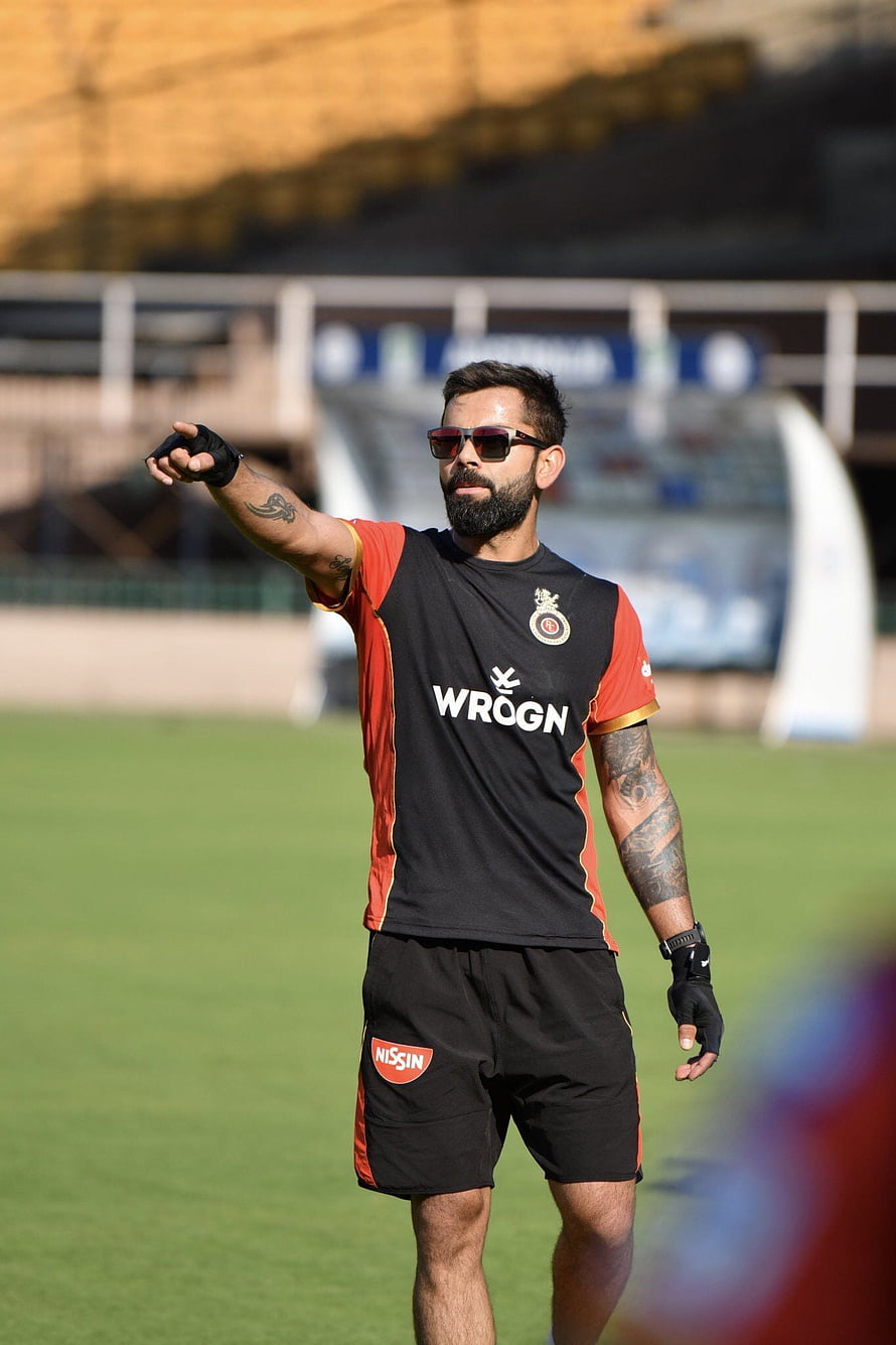Virat Kohli in RCB Training Kit Pointing on Cricket Field HD phone wallpaper