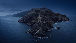 Aerial View of a Rugged Coastal Island at Night Under a Starry Sky HD wallpaper