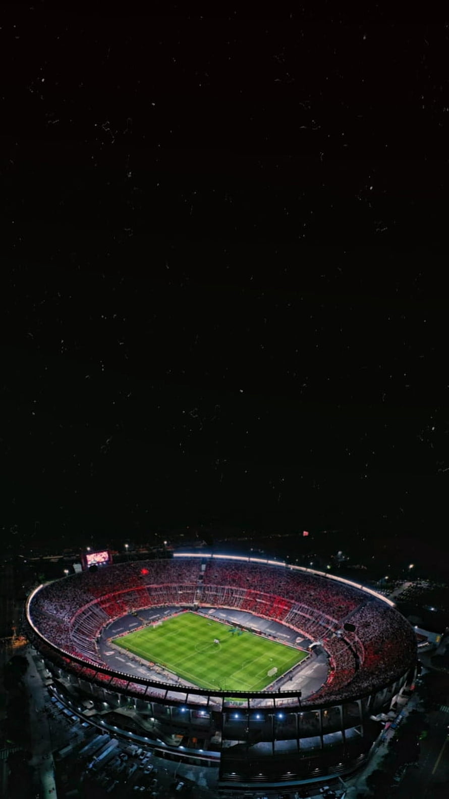 Aerial Night View of a Packed Soccer Stadium with Illuminated Green Pitch and Red Crowd HD phone wallpaper