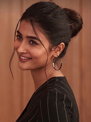 Pooja Hegde in a black pinstripe top with a high bun and hoop earrings HD phone wallpaper