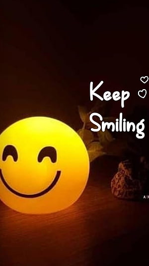 Glowing Yellow Smiley Face Lamp on Wooden Surface with Keep Smiling Text HD phone wallpaper
