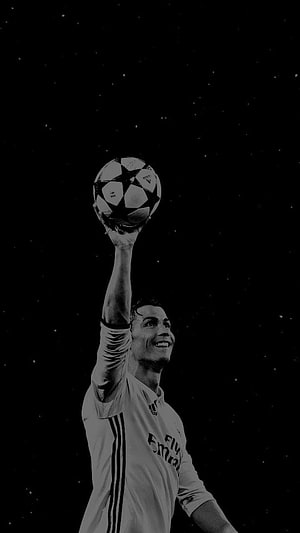 Cristiano Ronaldo holding Champions League trophy in Real Madrid kit black and white HD phone wallpaper
