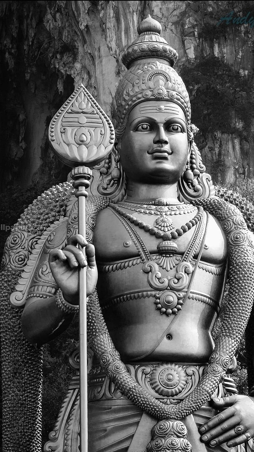 Black and white portrait of a detailed Hindu deity statue holding a staff with ornate jewelry and crown HD phone wallpaper