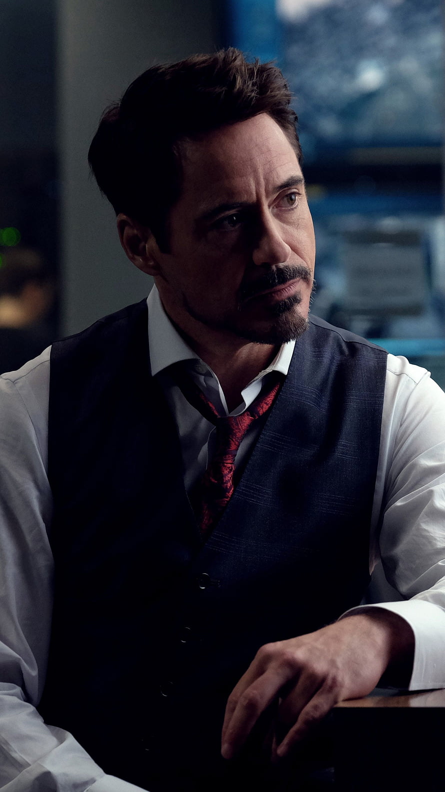 Robert Downey Jr as Tony Stark in a dark vest and red tie with a serious contemplative expression HD phone wallpaper