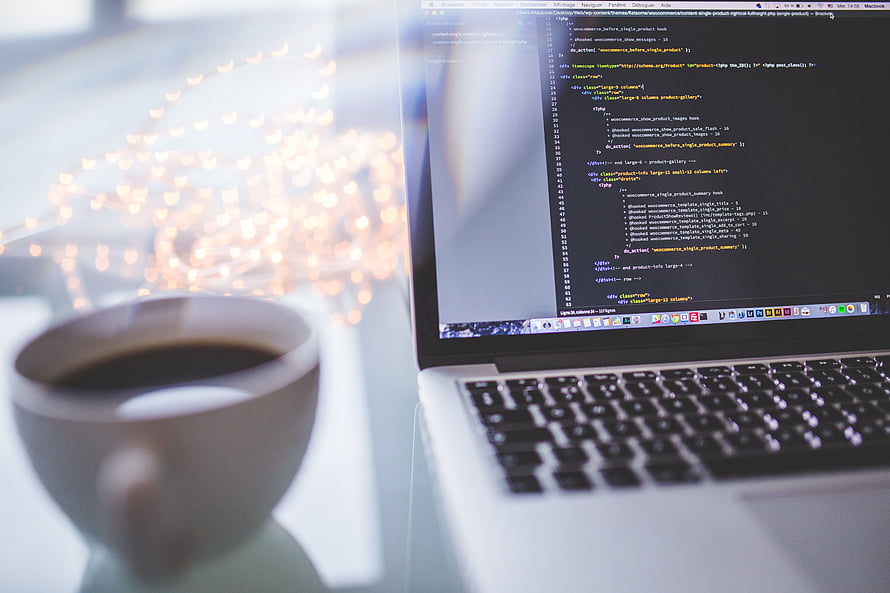 Laptop displaying code editor with coffee cup and bokeh lights on desk HD wallpaper