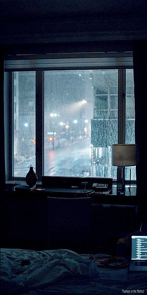 Moody Hotel Room Interior Looking Out at Rainy City Street at Night HD phone wallpaper