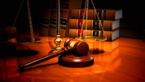 Wooden Gavel and Scales of Justice with Law Books on a Warm Wooden Desk HD wallpaper