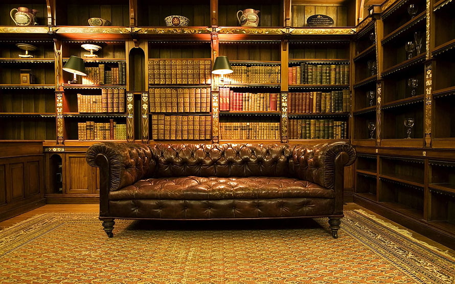 Classic Chesterfield Sofa in a Traditional Wood-Paneled Home Library with Antique Bookshelves HD wallpaper