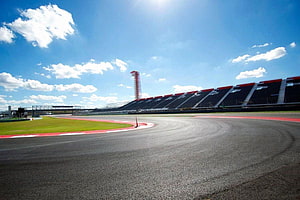 Empty Grand Prix Circuit With Grandstands And Control Tower Under Blue Sky HD wallpaper