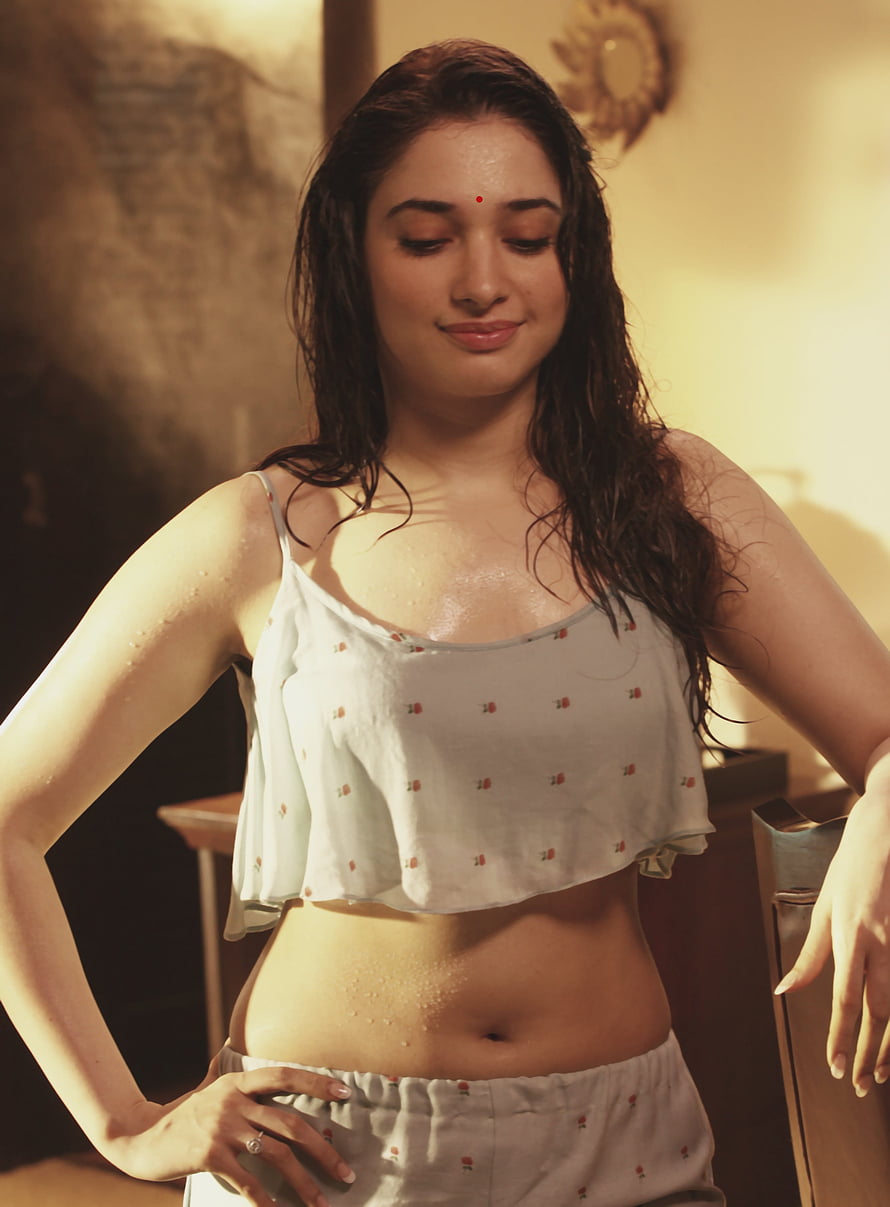 Tamannaah Bhatia in a white floral crop top with wet hair and warm indoor lighting HD phone wallpaper