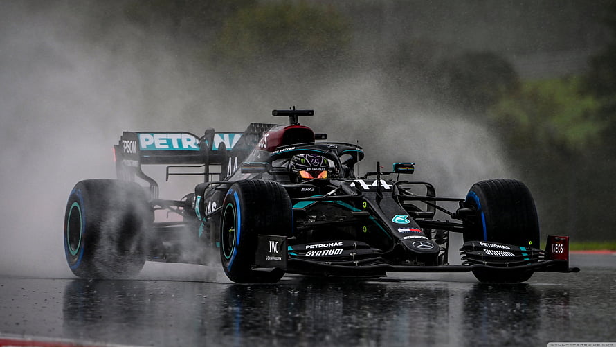 Lewis Hamilton Mercedes F1 Car Racing Through Rain Spray on Wet Track HD wallpaper
