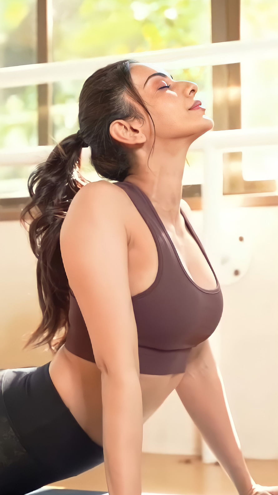 Rakul Preet Singh in a yoga pose wearing a brown sports bra and black leggings HD phone wallpaper