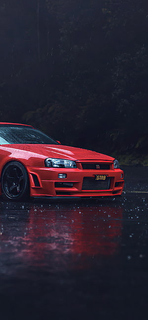 Red Nissan Skyline GT-R R34 parked on wet asphalt in the rain with reflections HD phone wallpaper