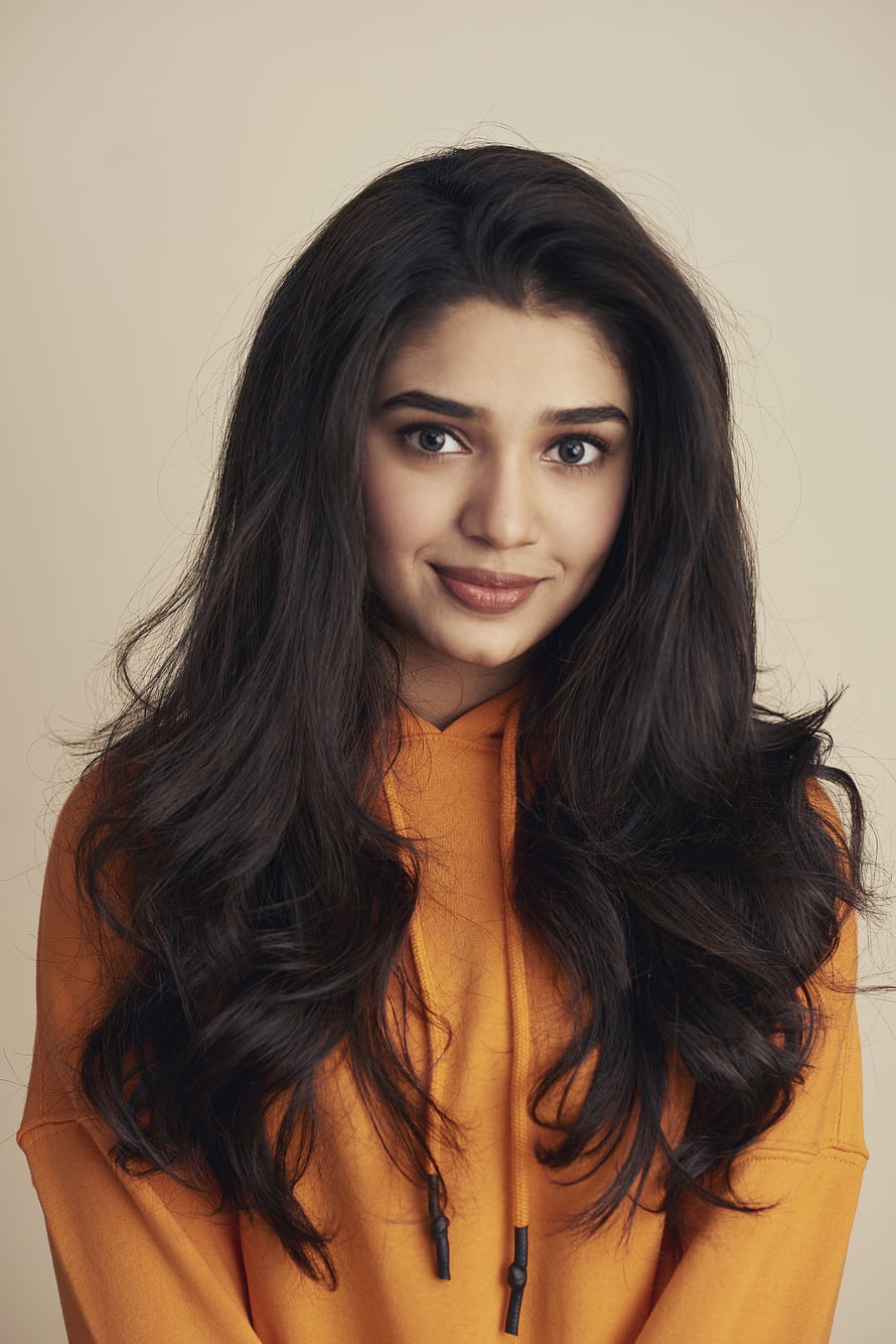 Krithi Shetty Portrait in Orange Hoodie with Long Wavy Hair HD phone wallpaper