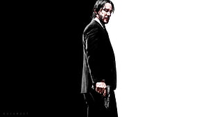 John Wick in black suit holding gun against high contrast black and white background HD wallpaper
