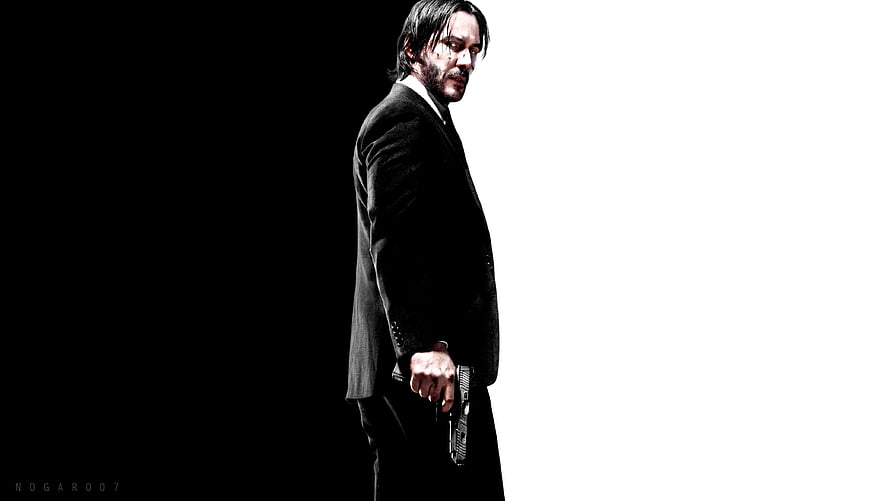 John Wick in black suit holding gun against high contrast black and white background HD wallpaper