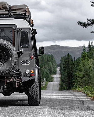 Rear View of a Classic Land Rover Defender on a Forest Road HD phone wallpaper