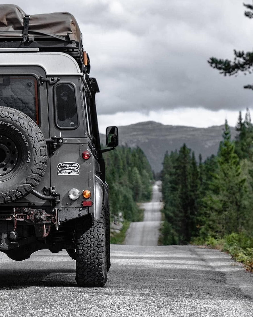 Rear View of a Classic Land Rover Defender on a Forest Road HD phone wallpaper