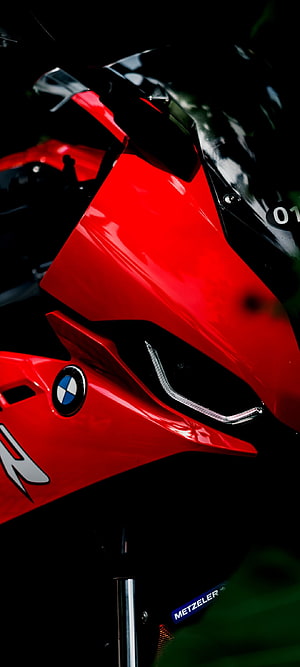 Close-up of a red BMW S1000RR superbike front fairing and headlight HD phone wallpaper