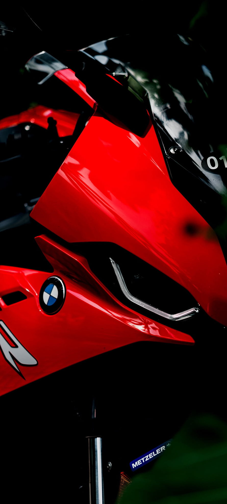 Close-up of a red BMW S1000RR superbike front fairing and headlight HD phone wallpaper