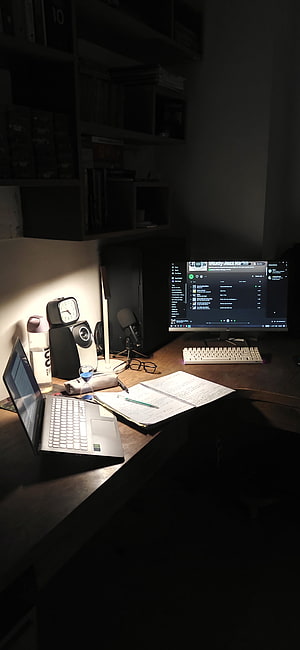 Cozy Night Study Desk Setup with Laptop, Monitor, and Warm Lighting HD phone wallpaper