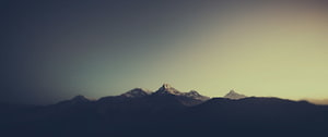 Majestic Snow-Capped Mountain Peaks Silhouetted Against a Golden Sunset Sky HD wallpaper