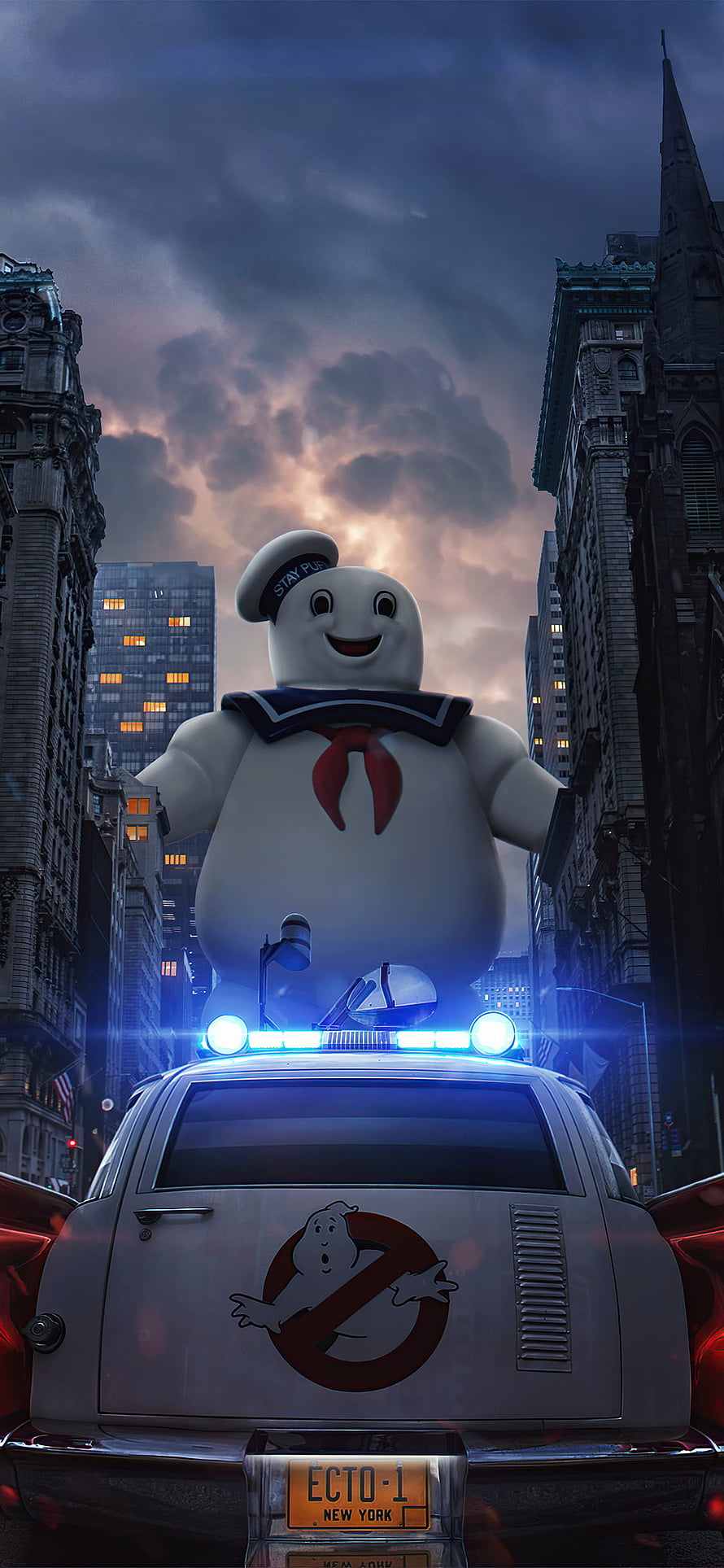 Cute Ghostbusters Mascot Standing on Ecto-1 in a Dramatic City Street at Dusk HD phone wallpaper
